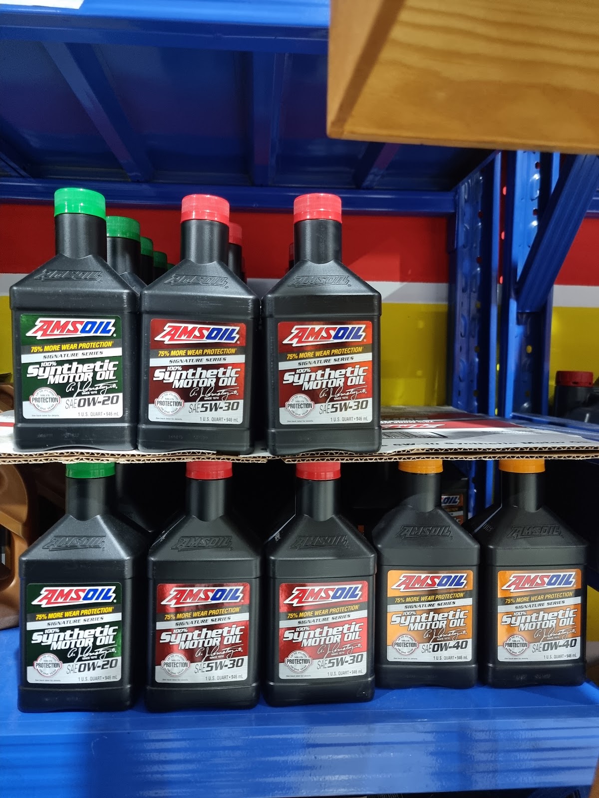 Eight one-quart bottles of AMSOIL Signature Series 100 percent synthetic motor oil on a shelf, in 0W-20, 5W-30 and 0W-40