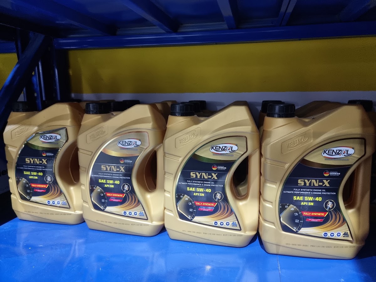 Four four-litre jugs of KENZOL SYN-X SAE 5W-40 fully synthetic engine oil on a shelf